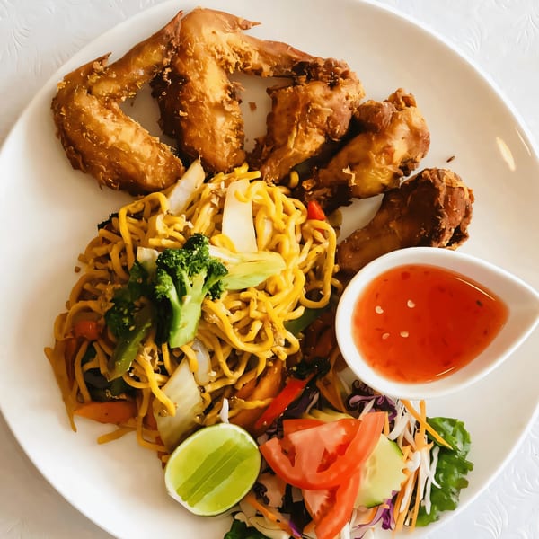 Thai Aroy Dee fried chicken wings, noodles with vegetables, sweet chili sauce, and a side salad.